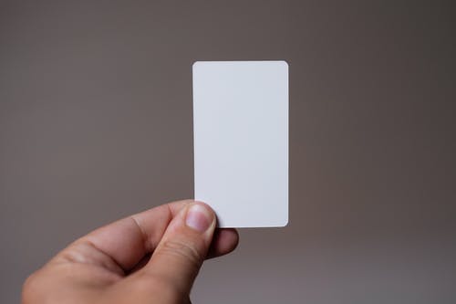 持白色矩形卡的人 · 免费素材图片
