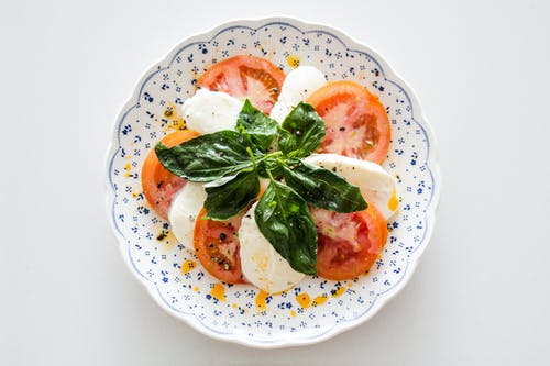 白色和蓝色的圆形花卉板上的蔬菜沙拉 · 免费素材图片