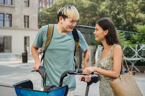 快乐多样的年轻夫妇，微笑着和抚摸自行车 · 免费素材图片