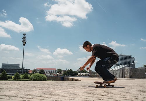 亚洲年轻男子骑滑板在城市 · 免费素材图片