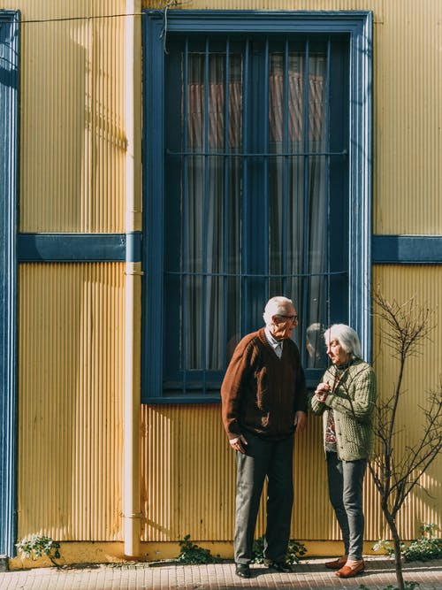 男人和女人站在建筑物的窗户前 · 免费素材图片