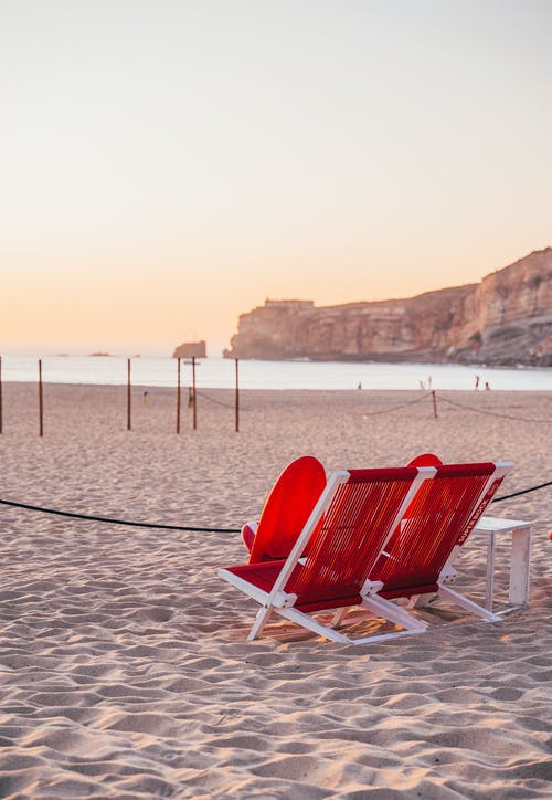 两把红白折叠椅在沙滩上 · 免费素材图片