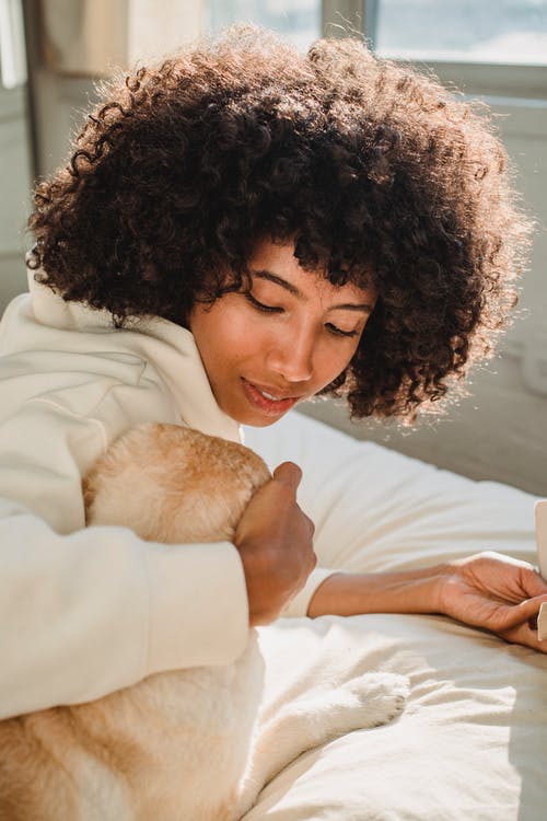 黑人发型抱着狗的黑人女性 · 免费素材图片