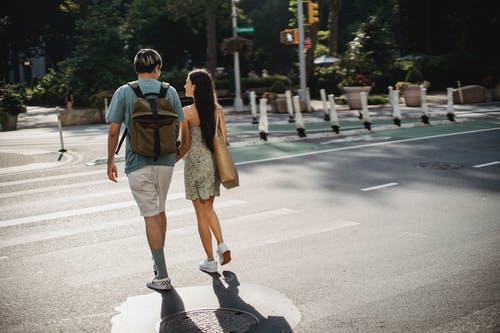 夫妻在阳光明媚的城市的道路上行走 · 免费素材图片