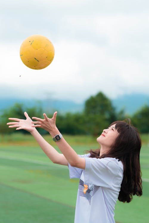 女子接球时穿着白色的t恤 · 免费素材图片