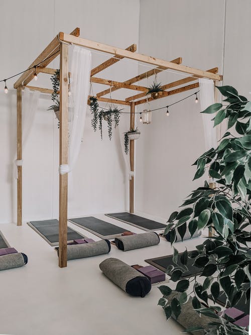 瑜伽垫上方的棕色木制框架雨棚 · 免费素材图片