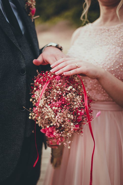 女人抱着红色和粉红色的花束 · 免费素材图片