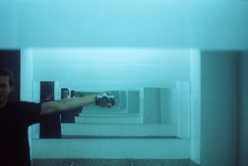 在镜子前照自己的照片的人 · 免费素材图片