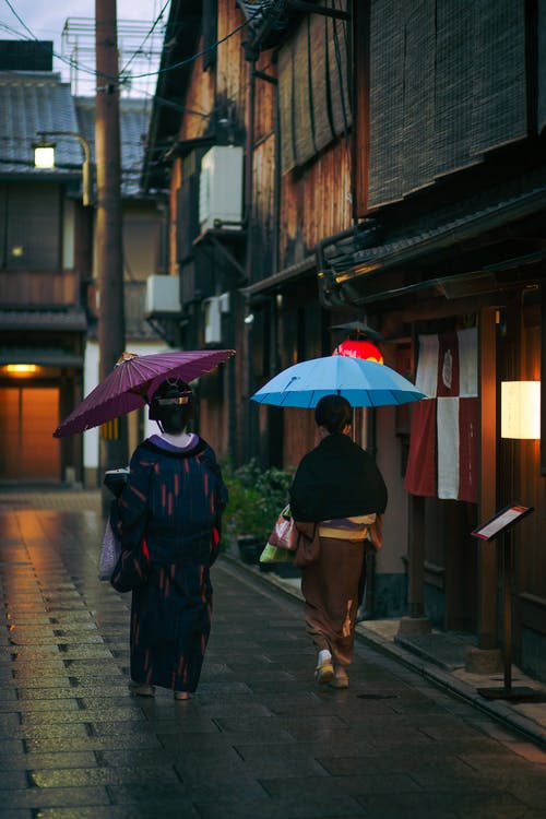 传统服装和遮阳伞走在一起的女人 · 免费素材图片