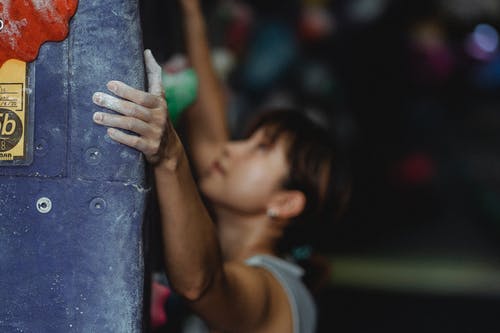 在抱石中心集中亚洲女性攀岩墙 · 免费素材图片