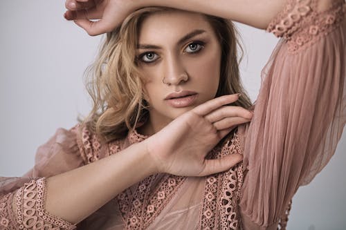 时兴的小姐用在头的手反对白色背景 · 免费素材图片