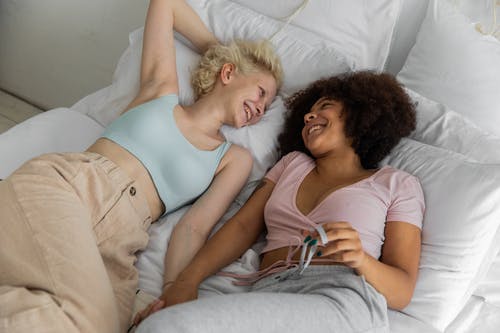 多种族的同性恋夫妇在床上开心地笑 · 免费素材图片