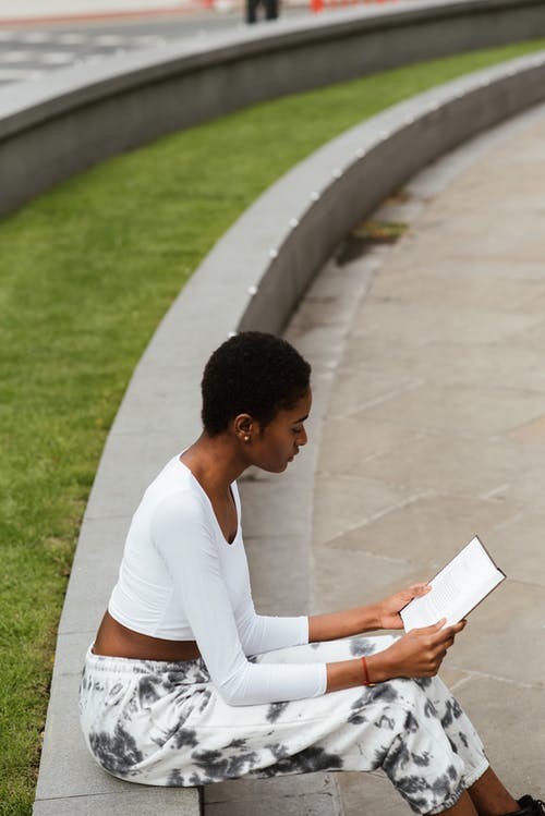 在夏季的一天在城市中的族裔女人阅读书 · 免费素材图片