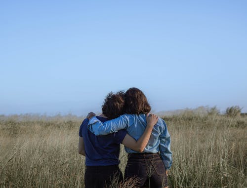 匿名女性朋友在宽敞的草地上拥抱 · 免费素材图片