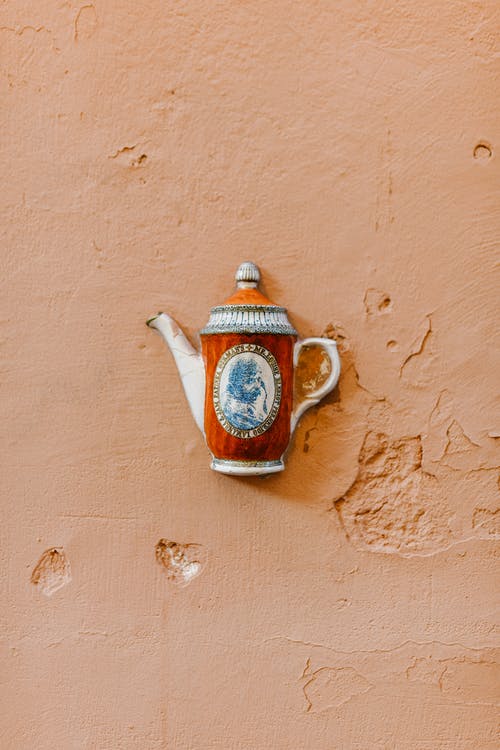 观赏茶壶放在破裂的混凝土表面 · 免费素材图片