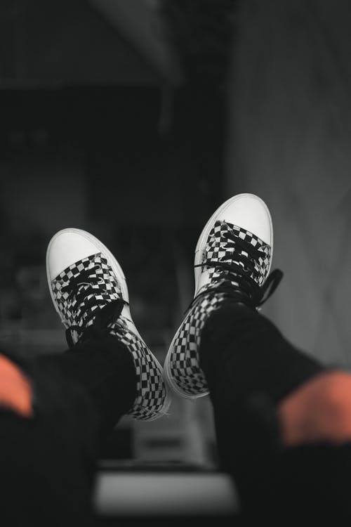 黑白棋盘格运动鞋的浅焦点摄影 · 免费素材图片