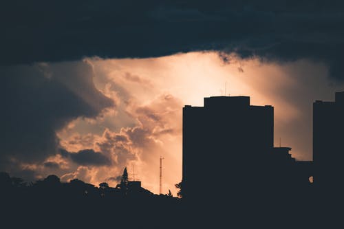 夕阳在多云的天空下建筑物的轮廓 · 免费素材图片