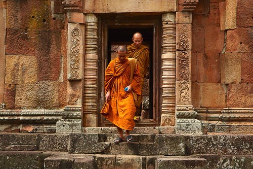 两名和尚穿着橙色长袍，走在混凝土楼梯上 · 免费素材图片