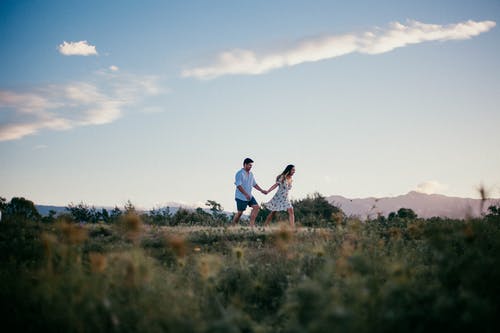男人和女人牵着手跑步 · 免费素材图片