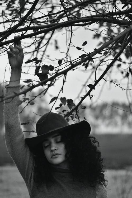 举起她的手时穿灰色毛衣的女人 · 免费素材图片