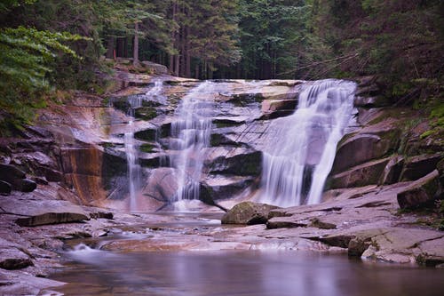 瀑布和河流被树木环绕的岩石 · 免费素材图片