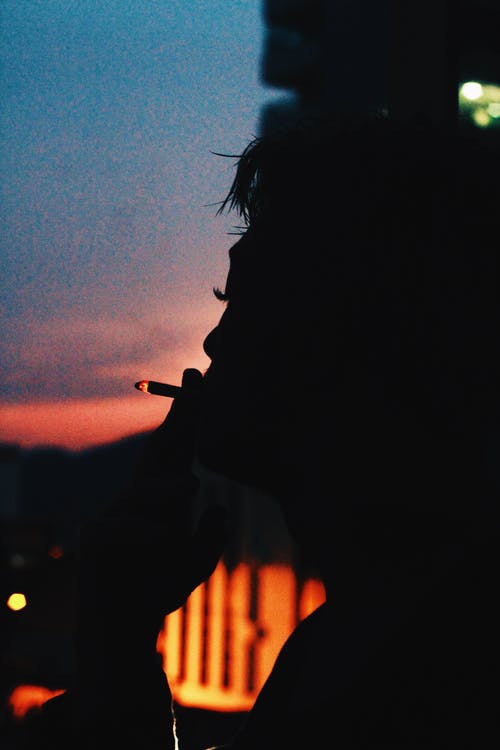 平静的人，在黑暗的夜晚燃烧着香烟 · 免费素材图片