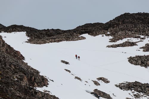 在雪山上行走的人 · 免费素材图片