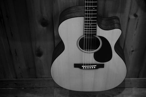 木栅栏上的原声吉他的灰度照片 · 免费素材图片