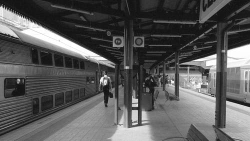 在火车站上行走的人的灰度照片 · 免费素材图片