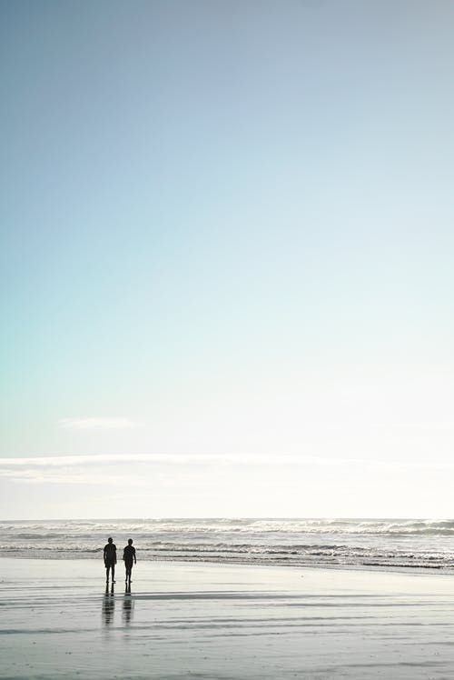 两人站在海边 · 免费素材图片