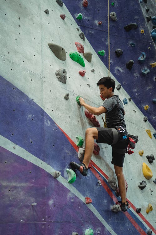 亚洲男子在攀岩墙上训练 · 免费素材图片