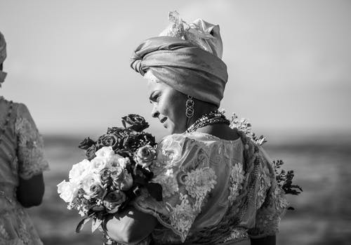 女人抱着鲜花花束的灰度照片 · 免费素材图片