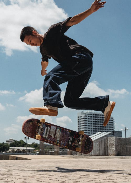亚洲年轻男子与滑板跳 · 免费素材图片