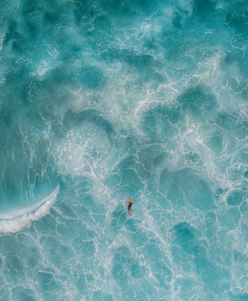 夏季旅行期间在绿松石海洋里游泳的匿名旅行者 · 免费素材图片
