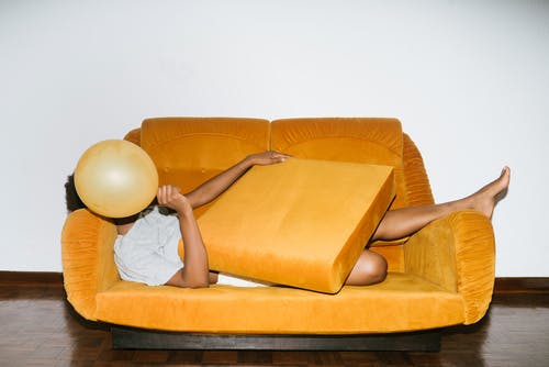 躺在橙色沙发上的人 · 免费素材图片