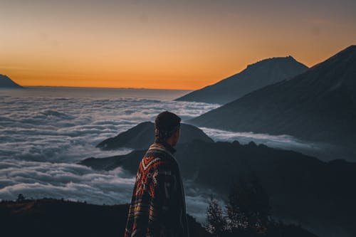 在日落时站在山顶上的男人 · 免费素材图片