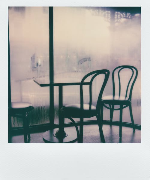 玻璃墙旁的桌子旁的黑色软垫椅子 · 免费素材图片