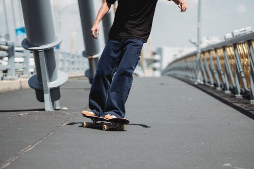 在城市桥梁上的不露面适合运动员滑板 · 免费素材图片
