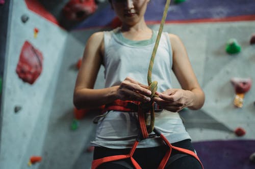 作物女登山者在安全带上绑皮带 · 免费素材图片