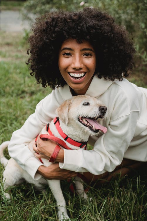幸福的黑女人在大街上拥抱狗 · 免费素材图片