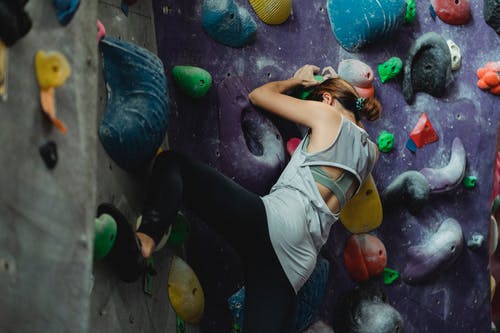 运动服的登山者在攀岩墙上锻炼 · 免费素材图片