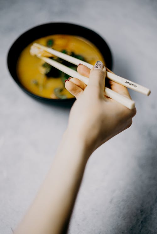 拿着筷子的人的照片 · 免费素材图片