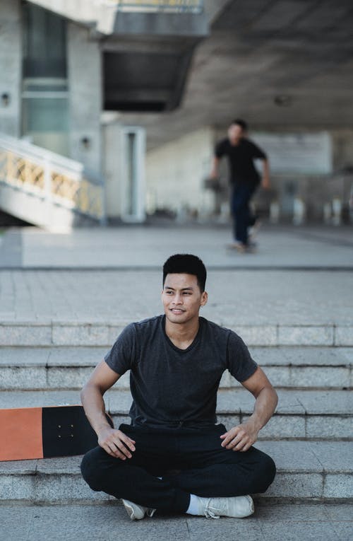 性格开朗的亚洲人，坐在莲花坐在街头的楼梯上 · 免费素材图片
