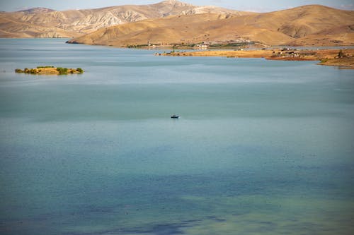 雄伟的丘陵山脉附近荡漾的蓝色湖泊 · 免费素材图片