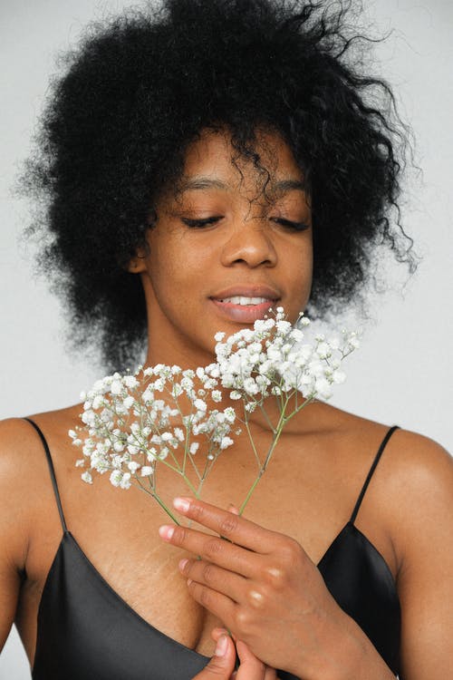 黑色意大利面条皮带顶白花的女人 · 免费素材图片