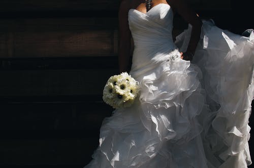 拿着花束的白色婚礼服的女人 · 免费素材图片