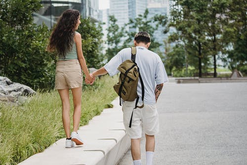时尚的年轻夫妇，牵着的手，走在城市公园 · 免费素材图片