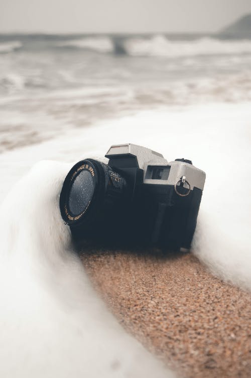 棕色沙滩上的黑色相机 · 免费素材图片
