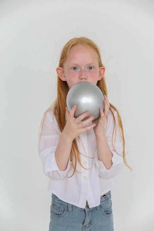 充气灰色气球的红头发的迷人女孩 · 免费素材图片