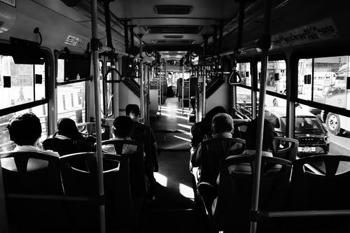 坐在公交车内的人的灰度照片 · 免费素材图片